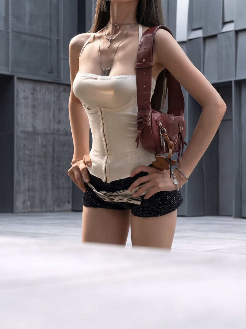 A diverse model wearing a modern halter cutout crop top against a minimalist, out-of-focus urban background.